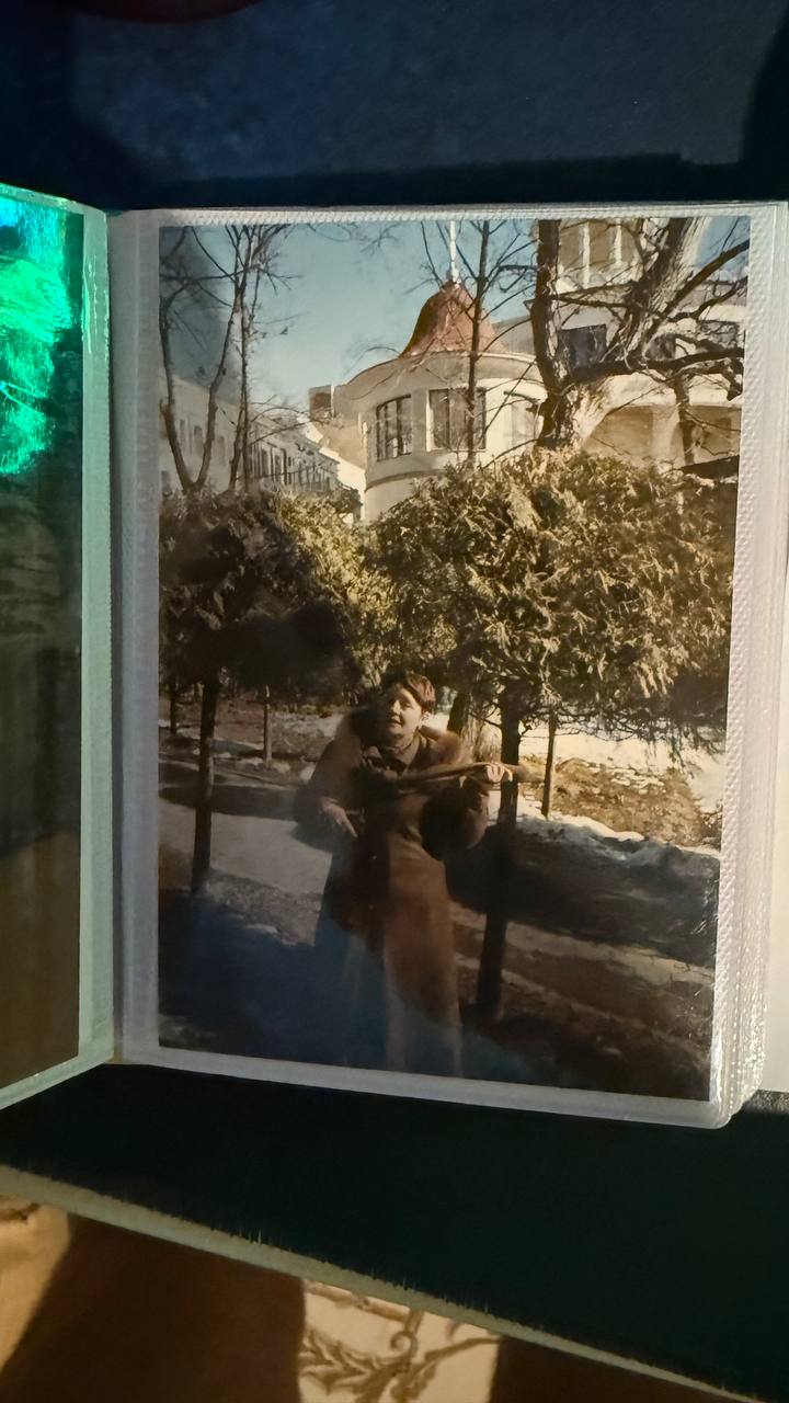 Страница семейного альбома с той же фотографией мамы в пальто на улице, снятая с другого ракурса