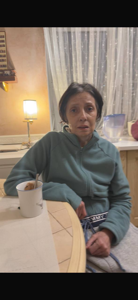 Мама сидит дома за столом с кружкой